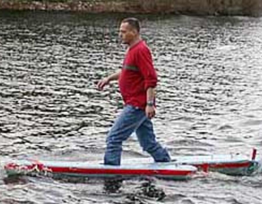 April 2002:   Newton, MA:  Yoav Rosen with a prototype of his walking-on-water
floatation apparatus, for which he received patent number 6,764,363. The
apparatus comprises a pair of bouyant wing-shaped floats and foot wells in the
floats designed to be under the center of boyancy in each float.  (Handout photo...
